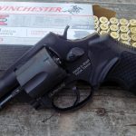 Taurus revolver propped against an open boc of Winchester white box ammunition