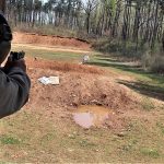 Bob Campbell shooting a 10mm pistol at an outdoor gun range