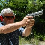 Bob Campbell shooting a 1911 10mm pistol with a two-handed grip