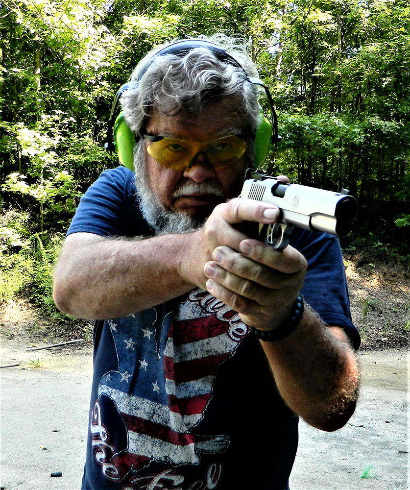 Bob Campbell shooting a 1911 10mm pistol with a two-handed grip