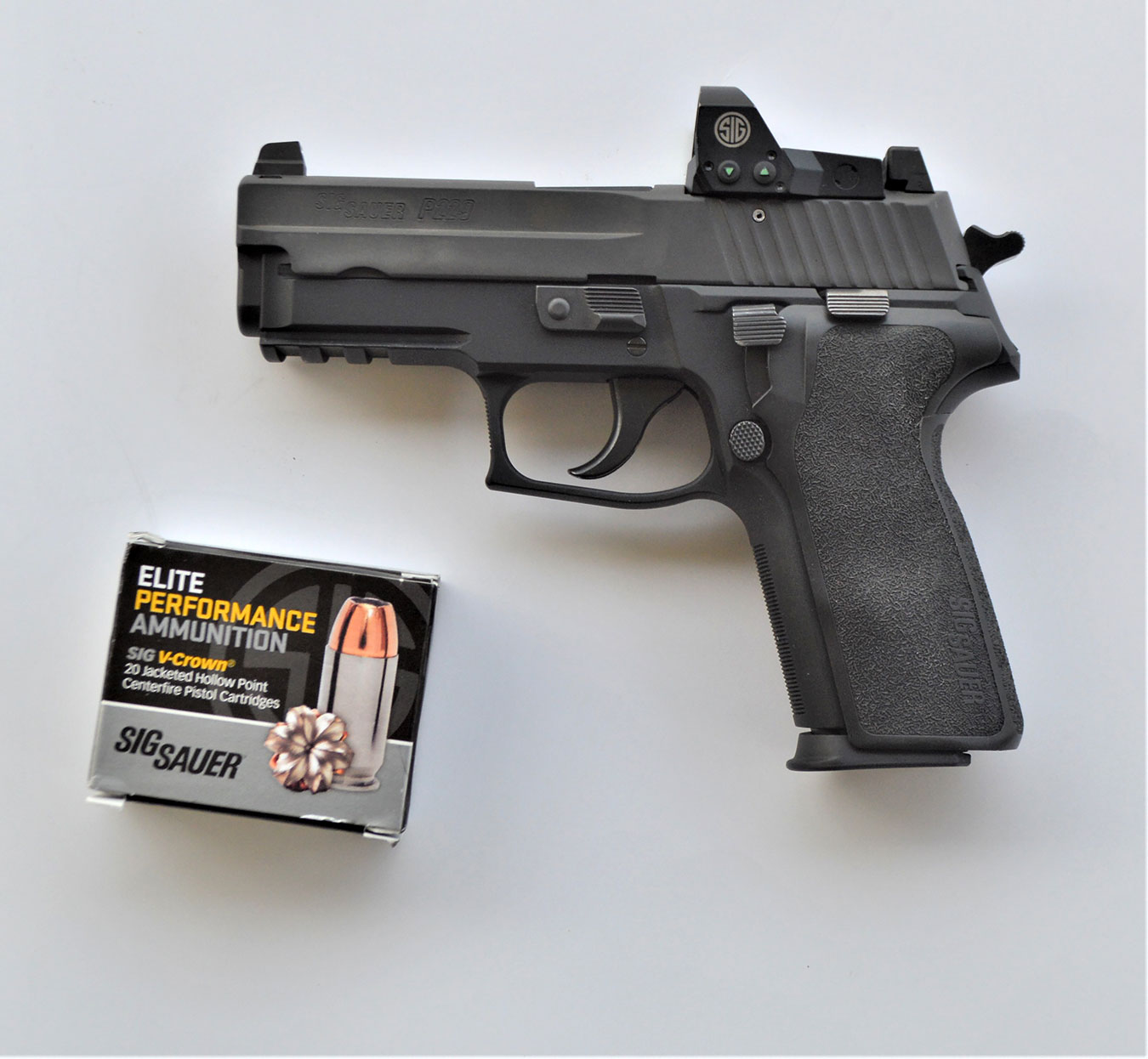 SIG Sauer P229 pistol left profile with one box of SIG ammunition
