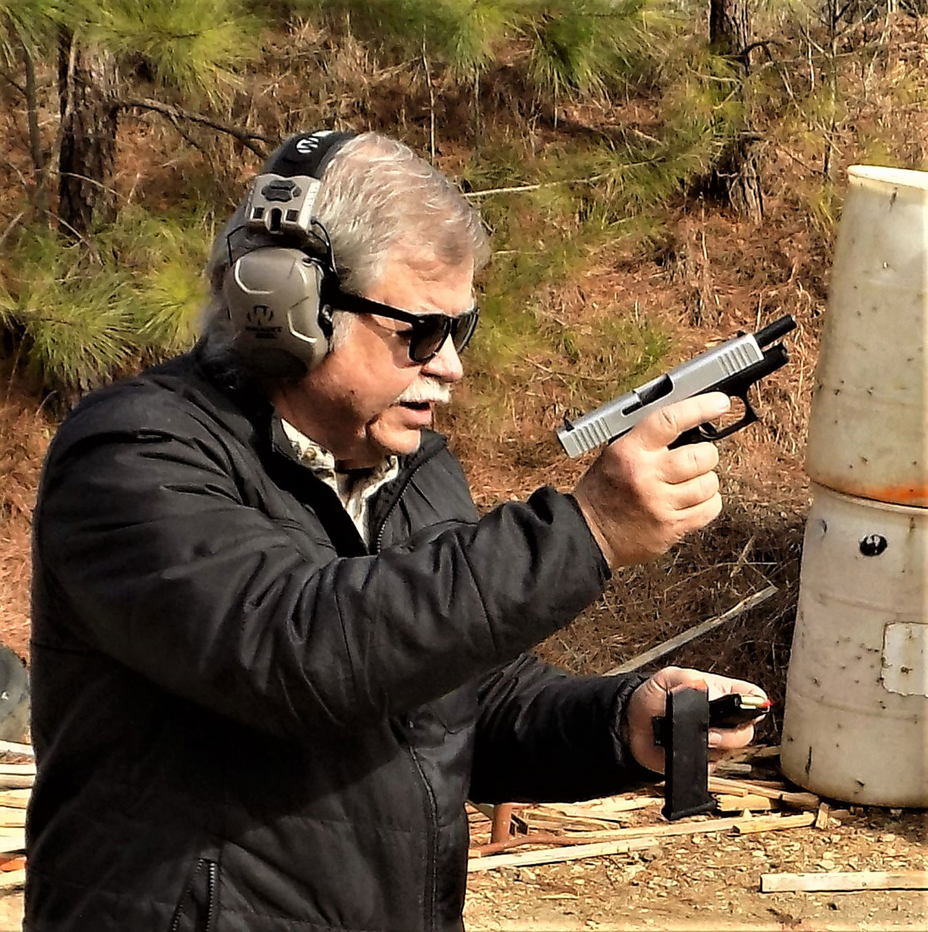 reloading a pistol with an empty magazine falling through the air to demonstrate the real deal in training