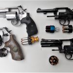Four revolver with open cylinders and loaded speedloaders