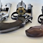 Three revolvers with open cylinders showing 5-, 6-, and 7-shot capacities