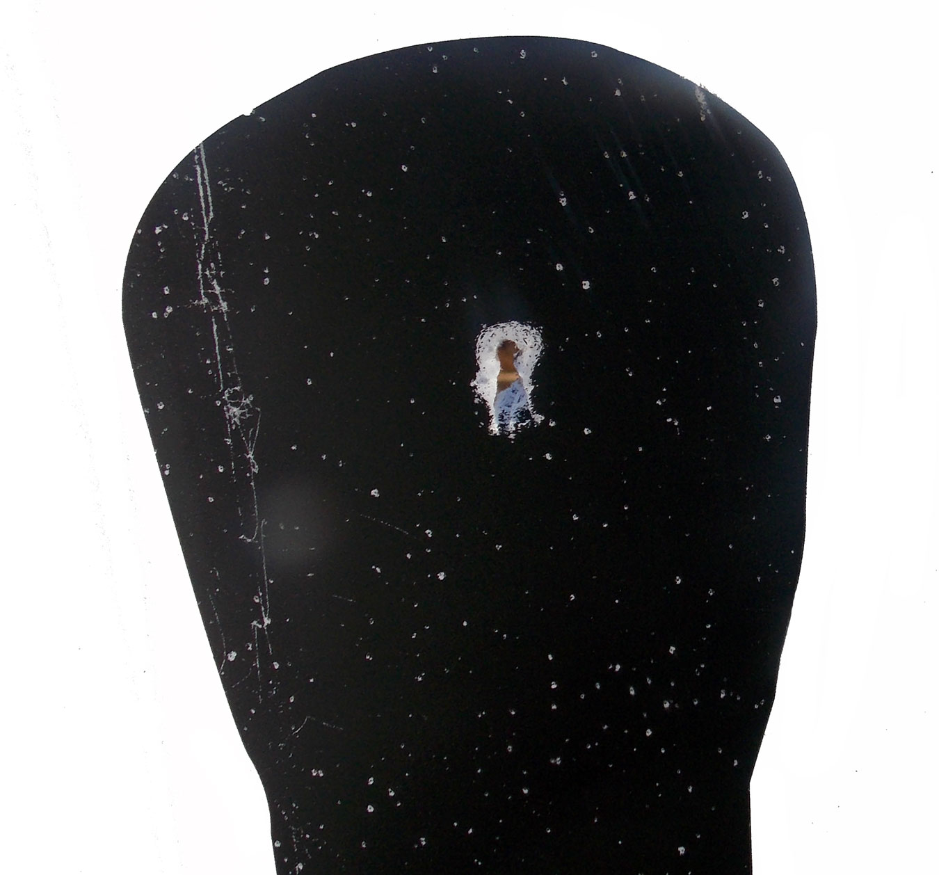 Single bullet hole in the center of a silhouette target's head