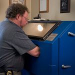 David Kenik working on a pistol in a sandblasting machine