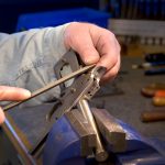 Hand filing the grip safety on a 1911 pistol to fit it to the frame