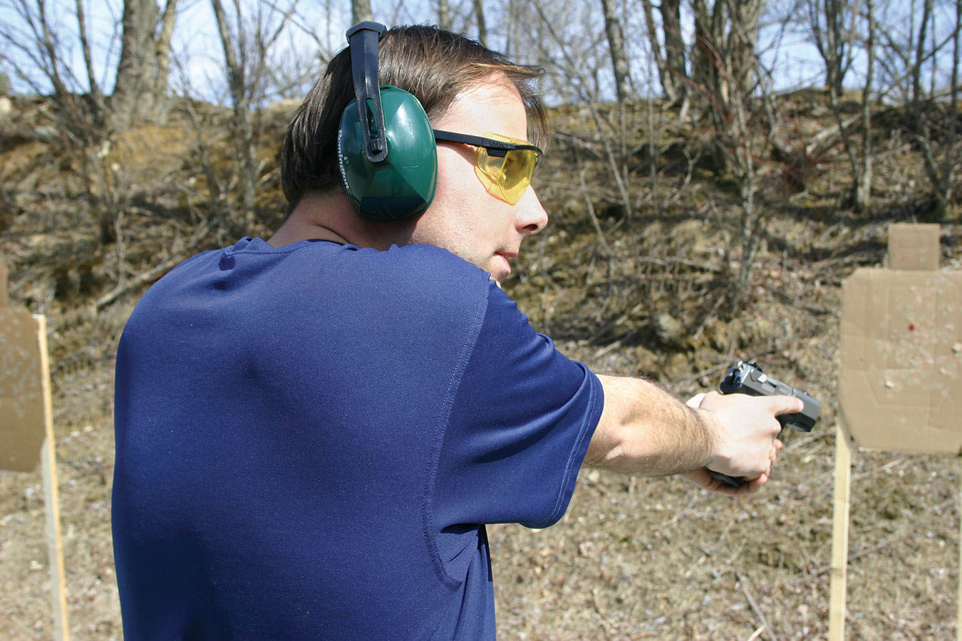 Man at a pistol range looking to the sides to check for additional threats for street training