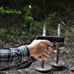 Wilburn Roberts shooting the Arex REx Delta with a two-handed grip