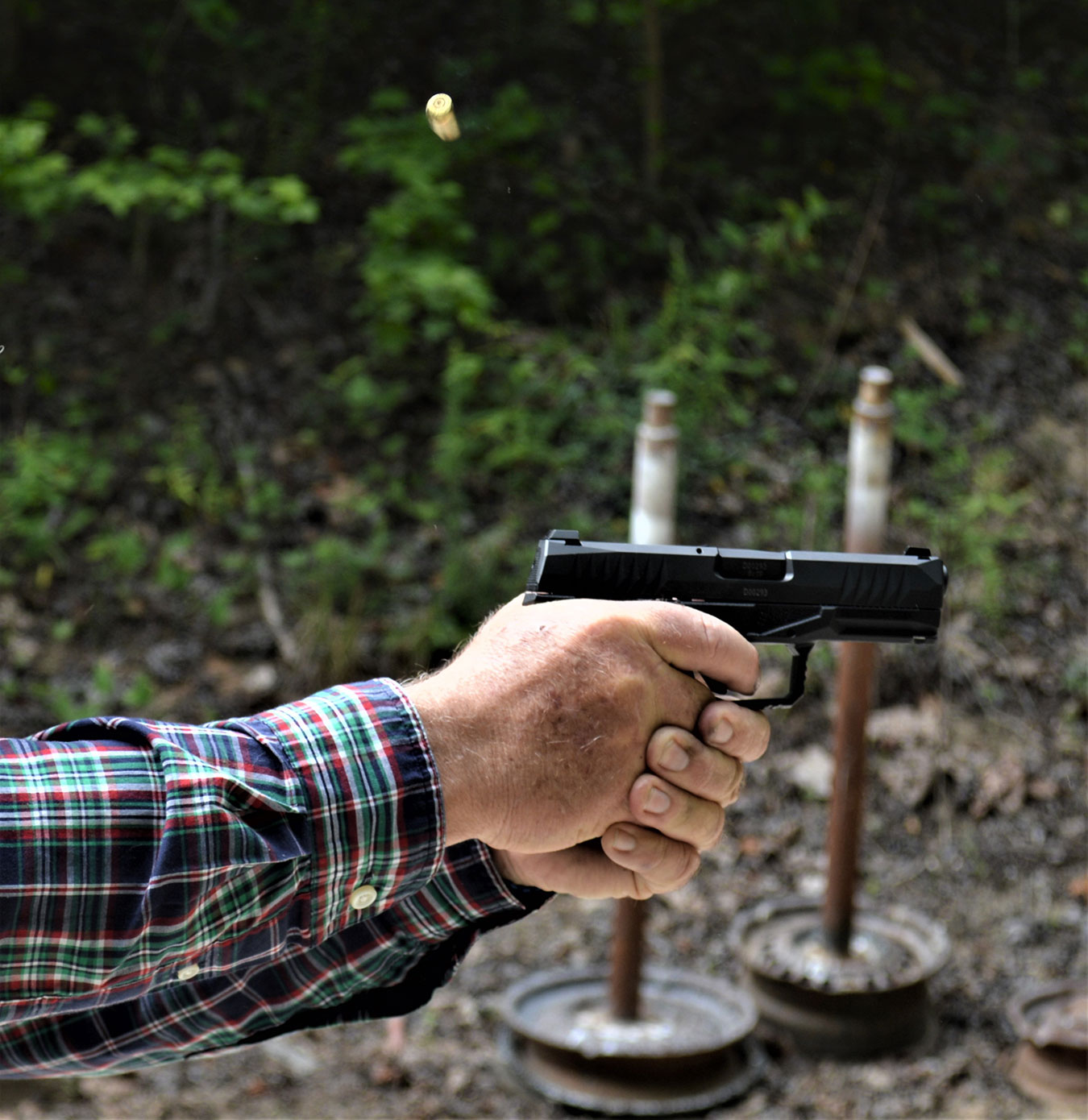 Wilburn Roberts shooting the Arex REx Delta with a two-handed grip