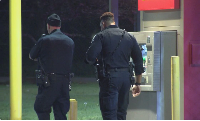 two armed good guys walking next to an ATM
