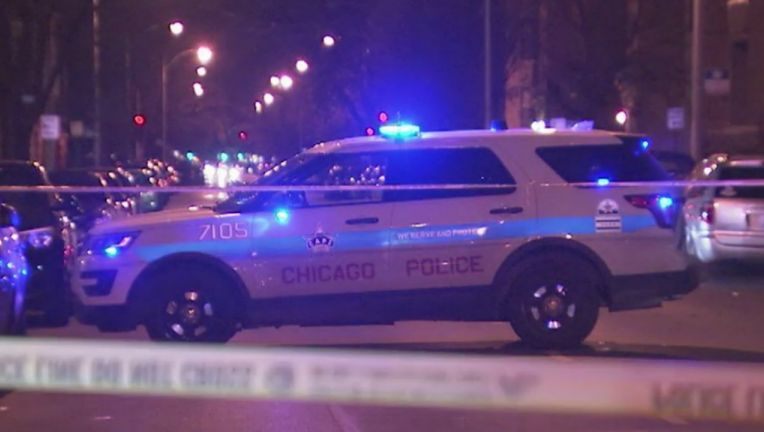 Police car with lights flashing behind crime scene tape