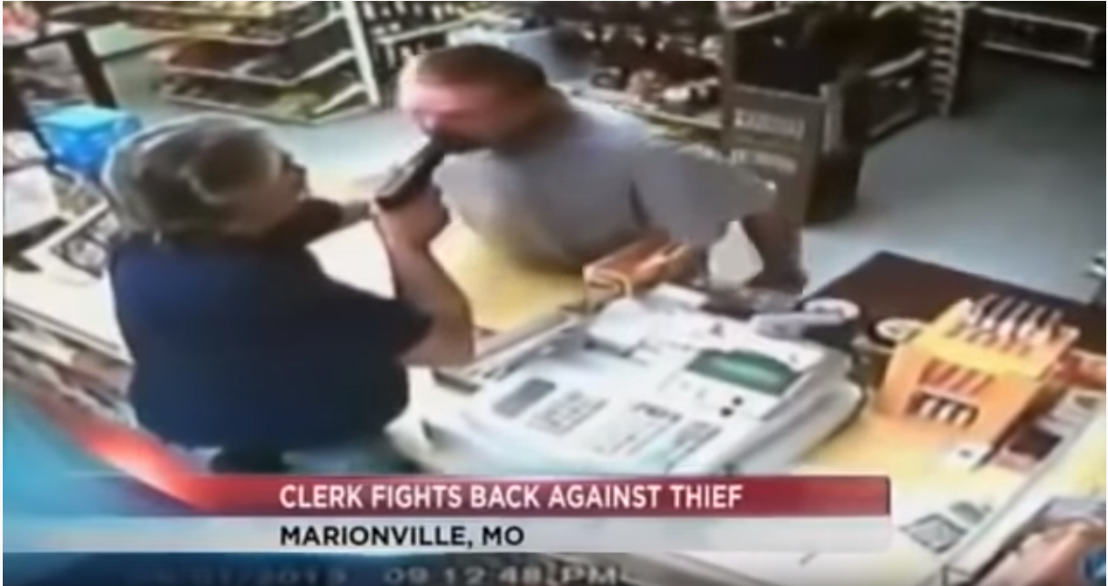 one of our armed good guys shoving a gun into a would-be robber's mouth