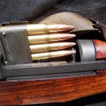 an en bloc clip being loaded into an M1 Garand rifle