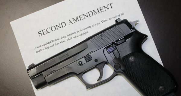 SIG Sauer pistol atop a copy of the Second Amendment